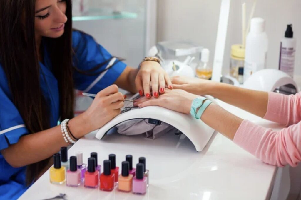 Manicurista realizando un servicio de uñas
